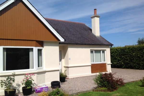 external view of a house with a fresh coat of white paint wuth wooden detailing below the windows