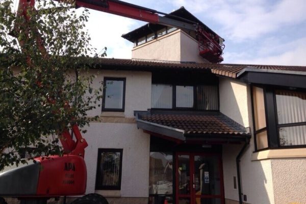 cherry picking lifting worker to paint external part of building